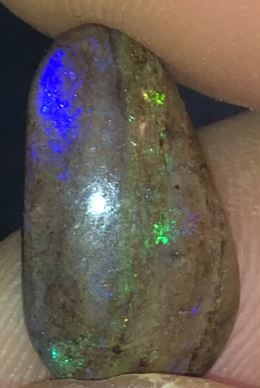 Earthy with flashes of purple and green in this pear shaped matrix opal