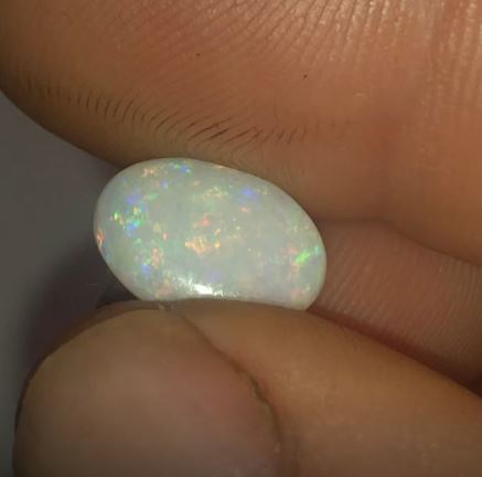 Green purple and red pinfire in this opal