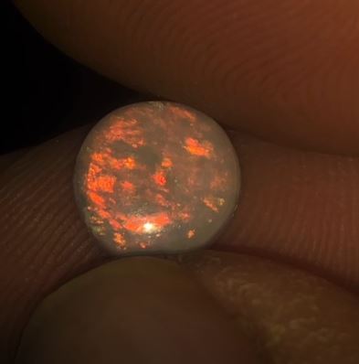 I see red, I see red, I see red. Red is the only colour in this nice round cut opal