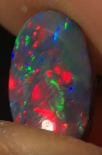 Stunning vibrant red, green and blue in this black opal