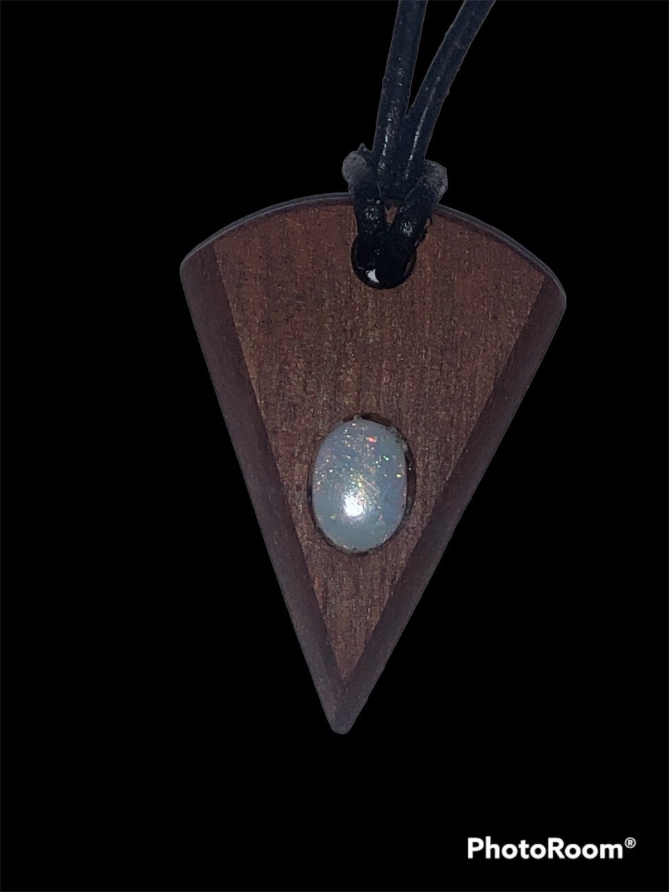 Timber arrowhead shaped pendant with a green and gold pinfire opal