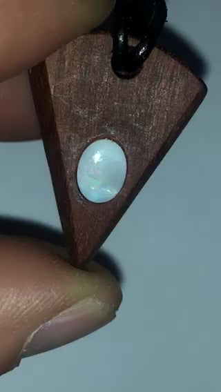 Timber arrowhead shaped pendant with a Coober Pedy opal