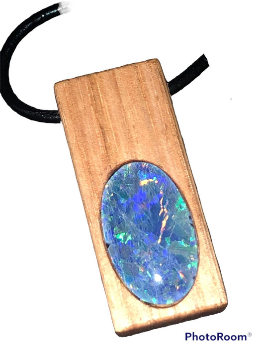 A large lighter coloured timber pendant with a large bright triplet opal.