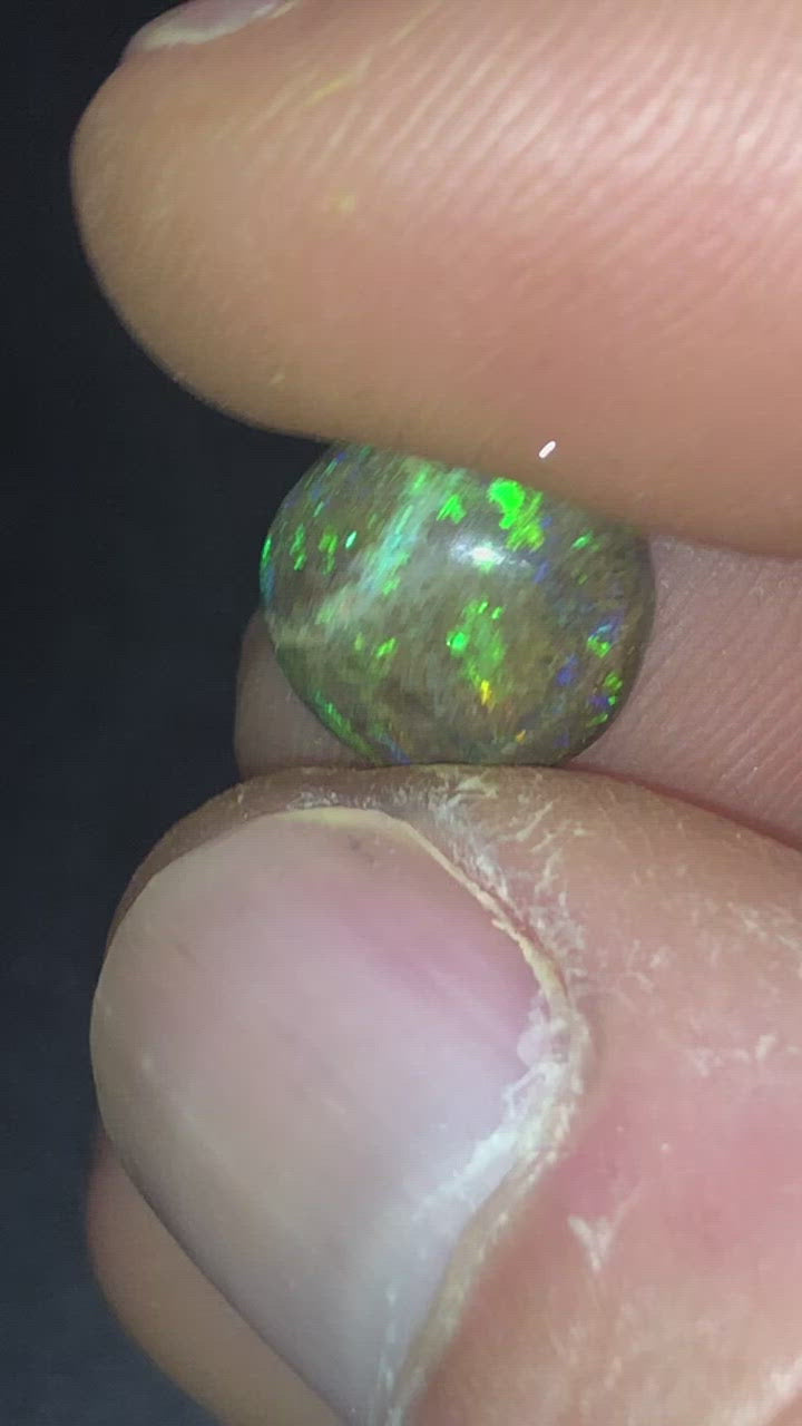 Vibrant flashes of purple green and orange in this round matrix opal.