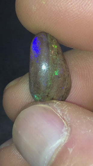 Earthy with flashes of purple and green in this pear shaped matrix opal