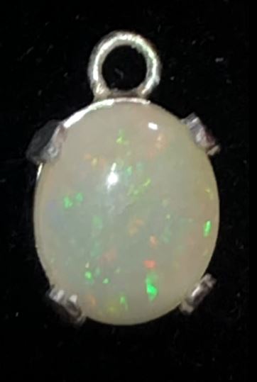 Red and green solid opal set in a silver pendant
