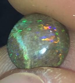 Vibrant flashes of purple green and orange in this round matrix opal.