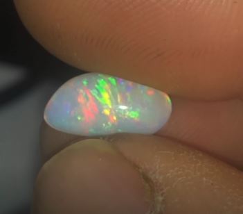 Vibrant splashes of red and green in this freeform opal