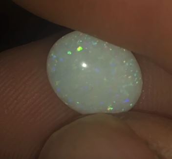 Green pinfire patterned oval shaped opal