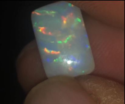 Rectangular cushion cut opal displaying multi-colours