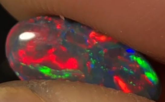 Stunning vibrant red, green and blue in this black opal