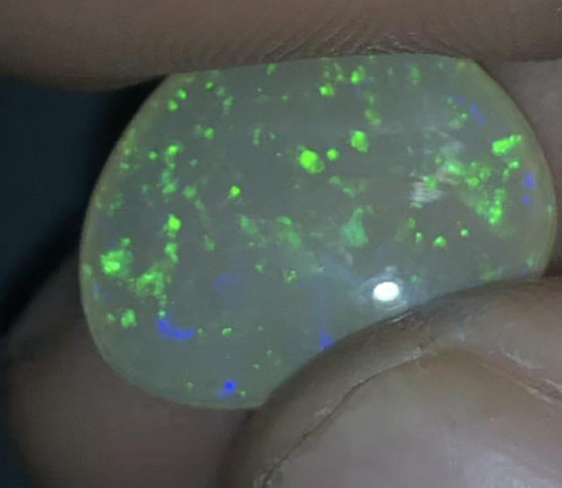 Green pinfire in a honey toned semi-crystal opal